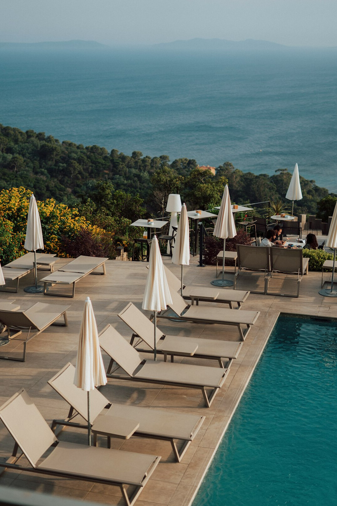 Luxury resort pool with sea view and loungers