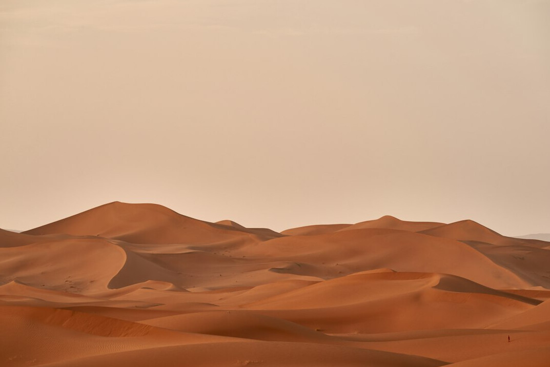 Golden sand dunes in a desert at sunset