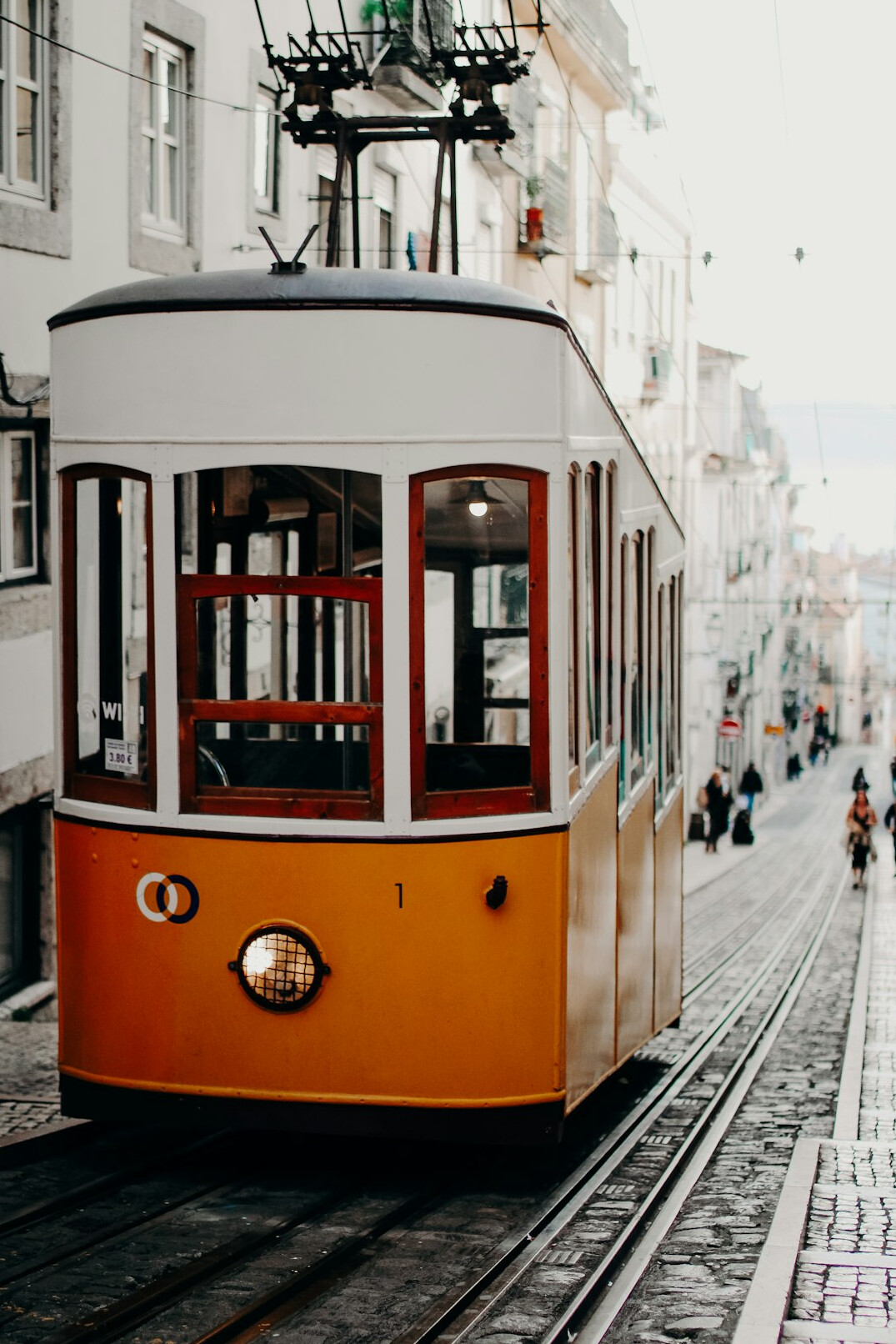 Yellow tram on a steep street in Lisbon