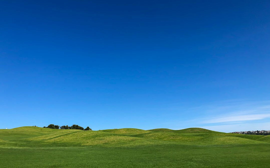 Green rolling hills under blue sky